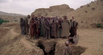 Movie still from “Life of Brian” (1979), directed by Terry Jones – A group of men standing next to each other on top of a cliff; Wide shot, High angle