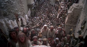 Movie still from “Life of Brian” (1979), directed by Terry Jones – A large group of men in white hats and robes; Extreme Wide shot, High angle