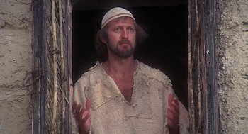 Movie still from “Life of Brian” (1979), directed by Terry Jones – A man with a beard wearing a white hat; Medium shot, Low angle