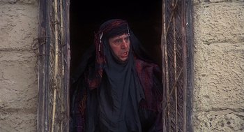 Movie still from “Life of Brian” (1979), directed by Terry Jones – A man wearing a black robe and a red head covering; Medium shot, Low angle