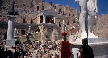 Movie still from “Life of Brian” (1979), directed by Terry Jones – A group of people in costumes standing in front of a building; Extreme Wide shot, High angle