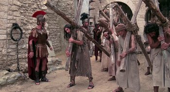 Movie still from “Life of Brian” (1979), directed by Terry Jones – A group of people dressed in ancient roman clothing; Wide shot, Low angle