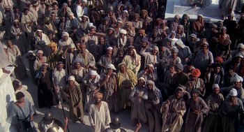 Movie still from “Life of Brian” (1979), directed by Terry Jones – A large group of men in brown robes and white hats; Extreme Wide shot, High angle