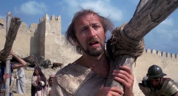 Movie still from “Life of Brian” (1979), directed by Terry Jones – A man with a beard holding a stick in a field; Close Up shot, Low angle