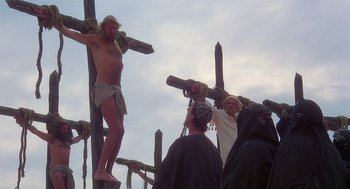 Movie still from “Life of Brian” (1979), directed by Terry Jones – A group of people standing next to each other on wooden crosses; Wide shot, Low angle