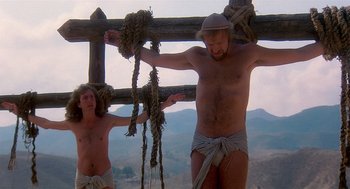 Movie still from “Life of Brian” (1979), directed by Terry Jones – A man and a woman hanging from a wooden fence; Medium shot, Low angle