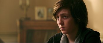 Movie still from “Morbius” (2022), directed by Daniel Espinosa – A young man with long brown hair looking to his left; Close Up shot, Over the shoulder angle