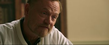 Movie still from “Morbius” (2022), directed by Daniel Espinosa – An older man wearing a white dress shirt and a tie; Close Up shot, Over the shoulder angle