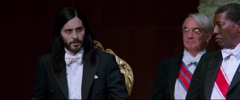 Movie still from “Morbius” (2022), directed by Daniel Espinosa – A man in a tuxedo sitting next to another man in a suit; Medium shot, Over the shoulder angle