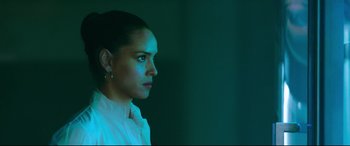Movie still from “Morbius” (2022), directed by Daniel Espinosa – A woman is looking into the distance in a dark room; Close Up shot, Low angle
