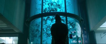 Movie still from “Morbius” (2022), directed by Daniel Espinosa – A person looking at a fish tank in a building; Wide shot, Low angle