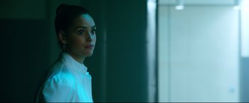 Movie still from “Morbius” (2022), directed by Daniel Espinosa – A woman in a white shirt is standing in a room; Close Up shot, Over the shoulder angle