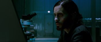 Movie still from “Morbius” (2022), directed by Daniel Espinosa – A man with a beard looking into a microscope; Close Up shot, High angle
