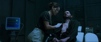 Movie still from “Morbius” (2022), directed by Daniel Espinosa – A woman in a black shirt and a man in a black shirt; Medium shot, Low angle