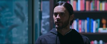 Movie still from “Morbius” (2022), directed by Daniel Espinosa – A man with long black hair wearing a black hoodie; Close Up shot, Over the shoulder angle