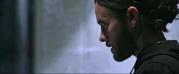 Movie still from “Morbius” (2022), directed by Daniel Espinosa – A person with a beard looking to the side; Close Up shot, Over the shoulder angle