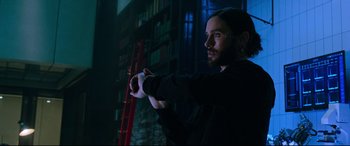 Movie still from “Morbius” (2022), directed by Daniel Espinosa – A man standing next to a ladder in a dark room; Medium shot, High angle