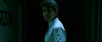 Movie still from “Morbius” (2022), directed by Daniel Espinosa – A man in a white shirt is standing in a dark room; Close Up shot, Over the shoulder angle