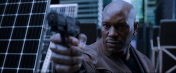 Movie still from “Morbius” (2022), directed by Daniel Espinosa – A man holding a gun while wearing a brown jacket; Close Up shot, Low angle