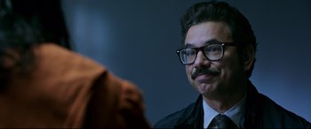 Movie still from “Morbius” (2022), directed by Daniel Espinosa – A person wearing a suit and glasses; Close Up shot, Over the shoulder angle