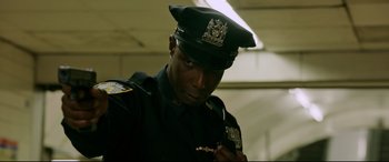 Movie still from “Morbius” (2022), directed by Daniel Espinosa – A man in a police officer's uniform holding a gun; Close Up shot, Low angle