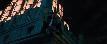 Movie still from “Morbius” (2022), directed by Daniel Espinosa – A man sitting on top of a building at night; Wide shot, Low angle