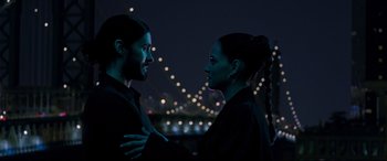 Movie still from “Morbius” (2022), directed by Daniel Espinosa – A man and a woman standing next to each other in front of lights; Medium shot, Over the shoulder angle