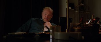 Movie still from “Morbius” (2022), directed by Daniel Espinosa – An older man sitting at a table in front of a computer; Close Up shot, Over the shoulder angle