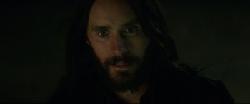Movie still from “Morbius” (2022), directed by Daniel Espinosa – A man with long black hair and a long beard; Close Up shot, Over the shoulder angle