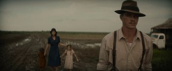 Movie still from “Mudbound” (2017), directed by Dee Rees – A man and a woman and a little girl standing in a field; Medium shot, Low angle