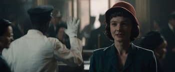 Movie still from “Mudbound” (2017), directed by Dee Rees – A woman wearing a red hat in front of a group of people; Close Up shot, Over the shoulder angle