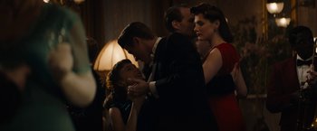 Movie still from “Mudbound” (2017), directed by Dee Rees – A group of people standing around a woman in a black suit; Medium shot, Over the shoulder angle