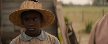 Movie still from “Mudbound” (2017), directed by Dee Rees – A person wearing a straw hat standing in a field; Close Up shot, Over the shoulder angle