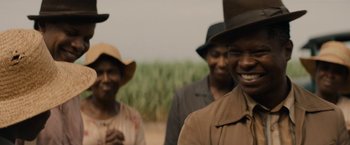 Movie still from “Mudbound” (2017), directed by Dee Rees – A group of people standing next to each other on a field; Close Up shot, Over the shoulder angle