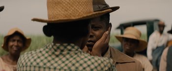 Movie still from “Mudbound” (2017), directed by Dee Rees – A man with a hat on touching his face; Close Up shot, Over the shoulder angle