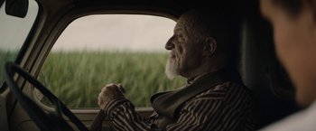 Movie still from “Mudbound” (2017), directed by Dee Rees – An older man driving a car with a beard; Close Up shot, Over the shoulder angle