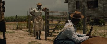 Movie still from “Mudbound” (2017), directed by Dee Rees – A couple of people standing next to each other on a dirt road; Medium shot, Over the shoulder angle