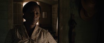 Movie still from “Mudbound” (2017), directed by Dee Rees – A woman is standing in a dark room; Close Up shot, Over the shoulder angle