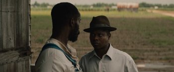 Movie still from “Mudbound” (2017), directed by Dee Rees – Two men standing next to each other on a field; Close Up shot, Over the shoulder angle