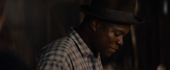 Movie still from “Mudbound” (2017), directed by Dee Rees – A man wearing a black hat and a plaid shirt; Close Up shot, Over the shoulder angle