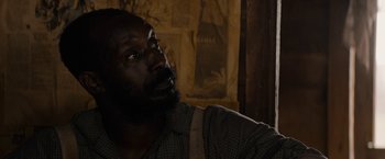 Movie still from “Mudbound” (2017), directed by Dee Rees – A man with a beard is looking up at the sky; Close Up shot, Over the shoulder angle
