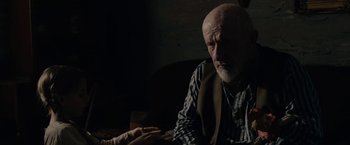 Movie still from “Mudbound” (2017), directed by Dee Rees – An older man sitting in front of a woman; Medium shot, Over the shoulder angle