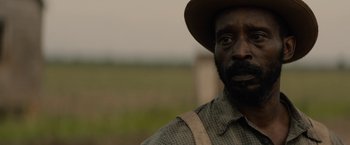 Movie still from “Mudbound” (2017), directed by Dee Rees – A man in a hat and a plaid shirt; Close Up shot, Over the shoulder angle