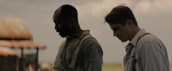 Movie still from “Mudbound” (2017), directed by Dee Rees – Two men standing next to each other on a field; Close Up shot, Over the shoulder angle