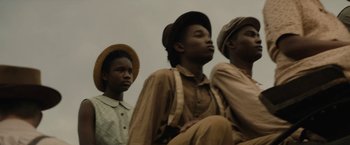 Movie still from “Mudbound” (2017), directed by Dee Rees – A group of young men standing next to each other; Medium shot, Low angle