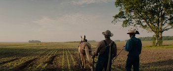 Movie still from “Mudbound” (2017), directed by Dee Rees – A man is plowing a field with a horse; Extreme Wide shot, Low angle