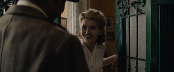 Movie still from “Mudbound” (2017), directed by Dee Rees – A young woman smiling at a man in a room with a green door; Close Up shot, Over the shoulder angle