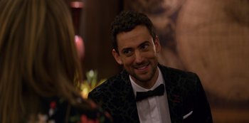 Movie still from “Murder Mystery” (2019), directed by Kyle Newacheck – A man in a tuxedo smiling for the camera; Close Up shot, Over the shoulder angle