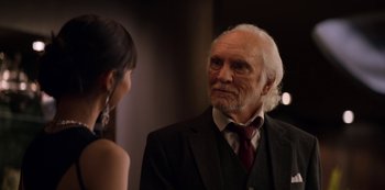 Movie still from “Murder Mystery” (2019), directed by Kyle Newacheck – An older man in a suit talking to a young woman; Close Up shot, Over the shoulder angle