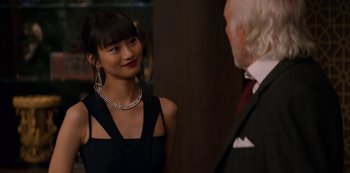 Movie still from “Murder Mystery” (2019), directed by Kyle Newacheck – A woman in a black dress talking to an older man; Close Up shot, Over the shoulder angle